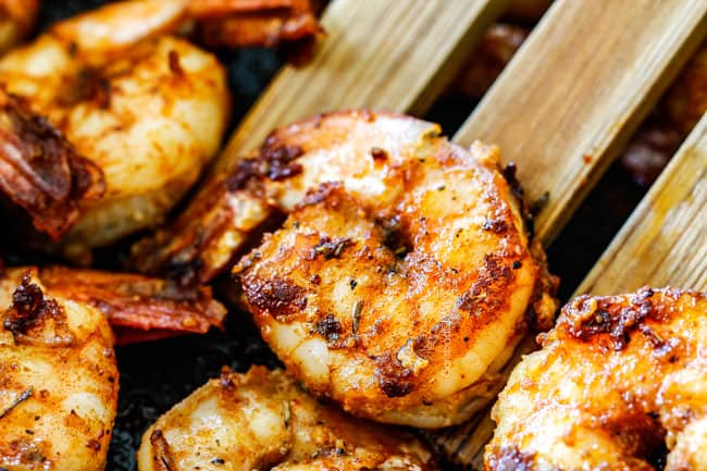 Showing how to make Shrimp Pasta Salad by cooking Cajun shrimp in a black pan