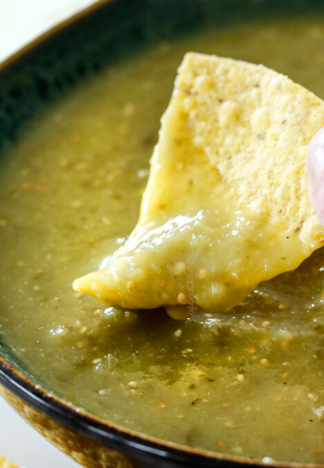 dipping tortilla chip into a bowl of best salsa verde