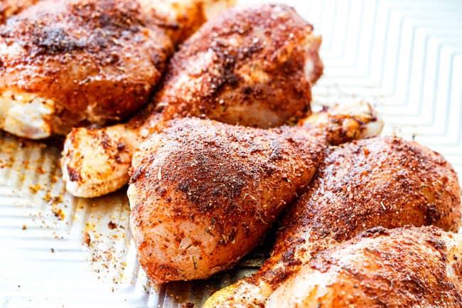 showing how to make grilled bbq chicken by rubbing chicken in a spice rub