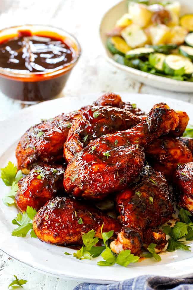 best grilled bbq chicken on a white plate garnished by parsley