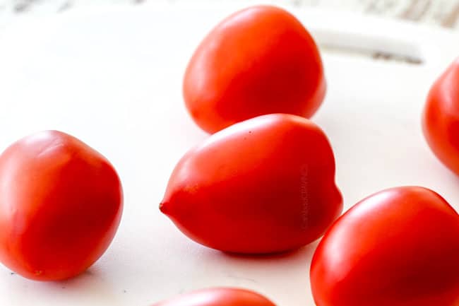 fresh roma tomatoes on a white cutting board showing how to make best pico de gallo