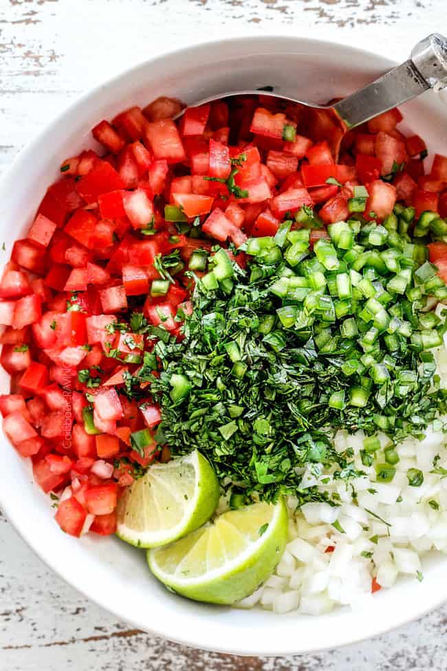top view of tomatoes, cilantro, onions, jalapenos, lime juice in a white bowl for the best pico de gallo recipe