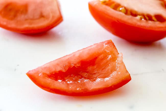 scooping out seeds of tomatoes showing how to make pico de gallo