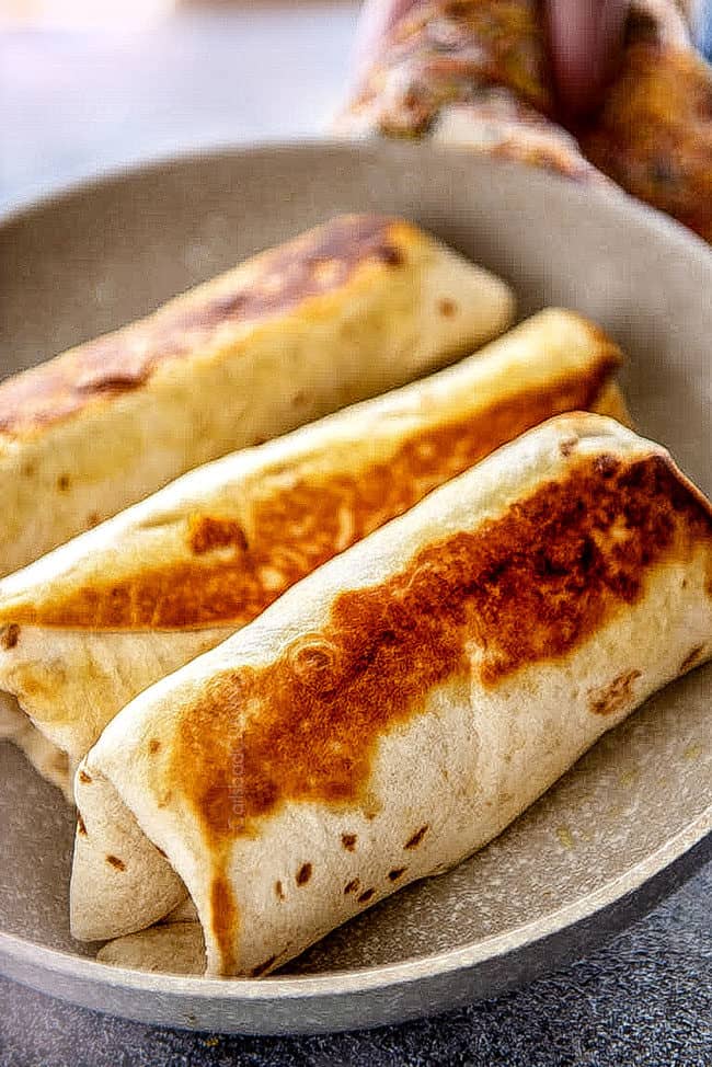 showing how to to make breakfast burritos by toasting burritos until golden