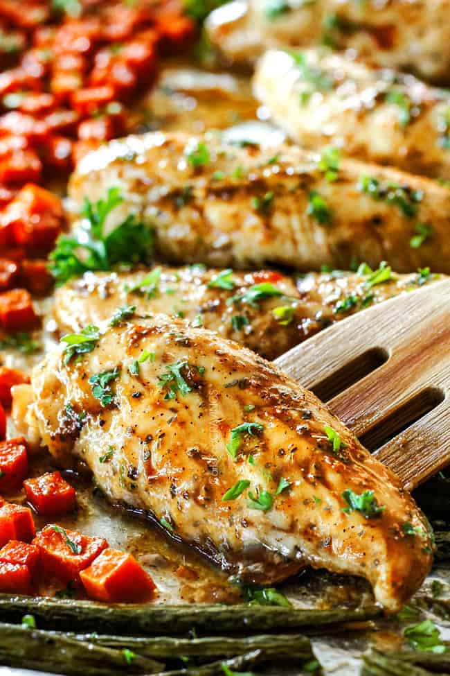 up close o sheet pan chicken breast and vegetables on a baking sheet with maple apricot glaze