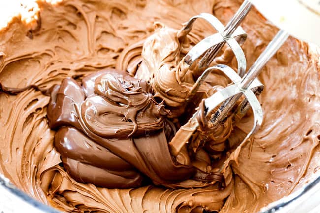 showing how to make pumpkin bars by whisking cream cheese and nutella together in a glass bowl to make the frosting