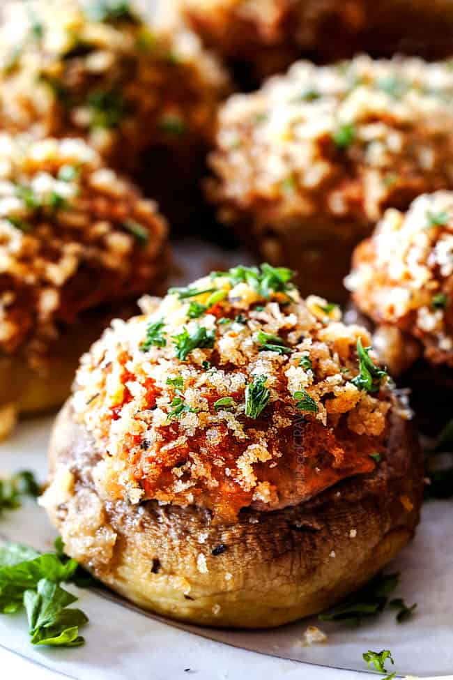 up close of easy Sausage Stuffed Mushrooms on a white serving plate