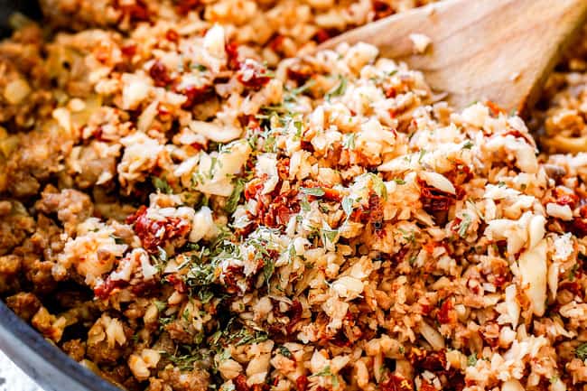 showing how to make best sausage stuffed mushrooms by adding chopped mushrooms and sun-dried tomatoes to sausage