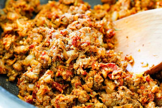 showing how to make sausage stuffed mushrooms by cooking filling with sausage in a skillet