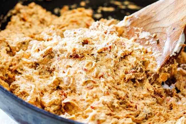 showing how to make best sausage stuffed mushrooms by adding cream cheese to sausage filling