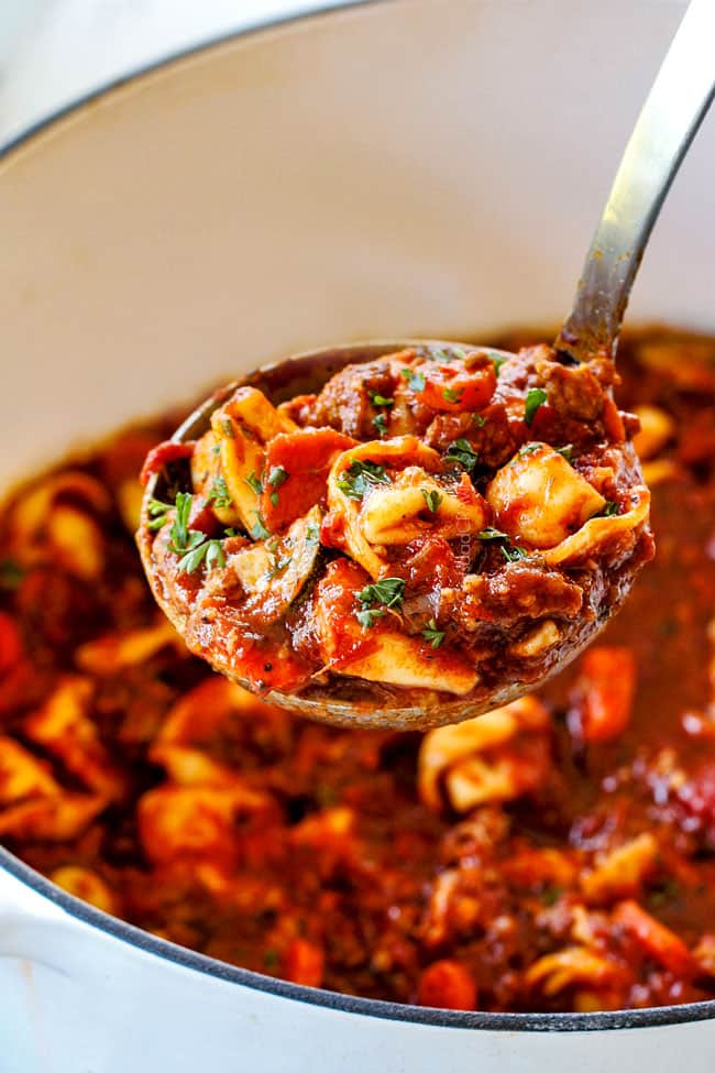 up close of a ladleful of Italian sausage tortellini soup