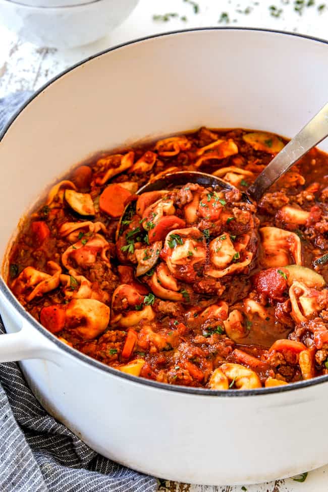 scooping a ladle of easy sausage tortellini soup