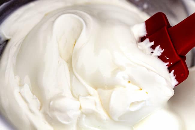 showing how to make ambrosia salad by mixing yogurt and cream together