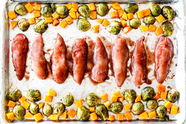showing how to make hoisin chicken by lining chicken tenders in a row on a sheet pan