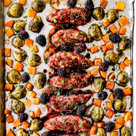 top view of hoisin chicken on a sheet pan with butternut squash and brussels sprouts