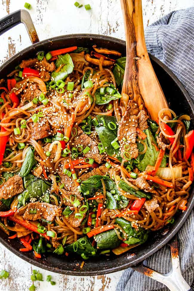top view of spicy Korean noodles with cellophane noodles, steak, mushrooms, carrots, onions, garlic