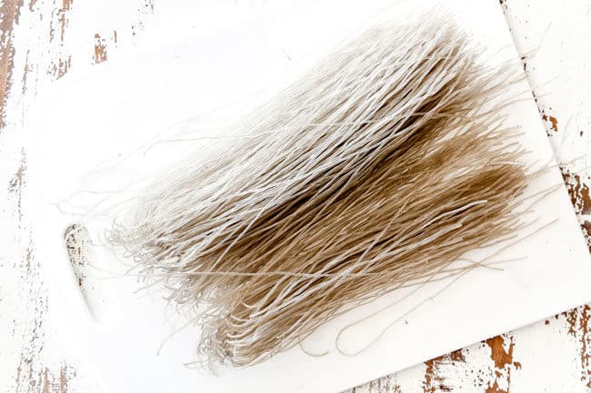 showing how to make Korean Spicy Noodles by laying glass noodles on a cutting board