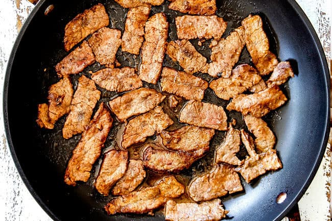 showing how to make Korean Spicy Noodles by cooking beef in a hot skillet
