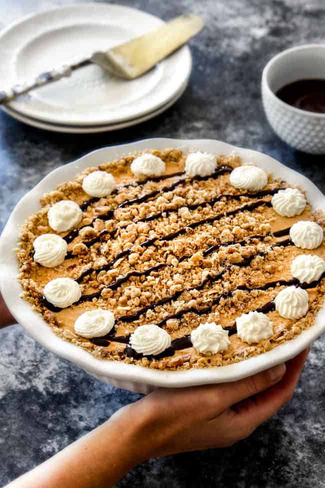 holding a pumpkin ice cream pie with two hands