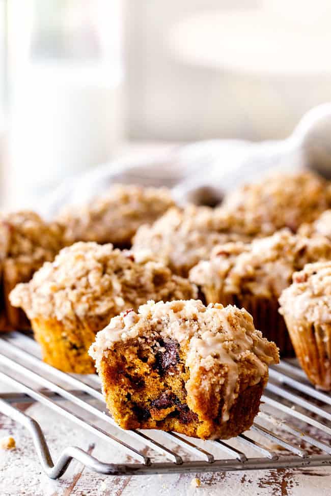 far away view of a pumpkin muffin from scratch with a bite out of it on a cooling rack
