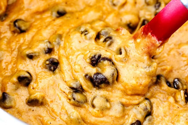 showing how to make pumpkin chocolate chip muffins by stirring chocolate chips into batter