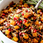 seasoned wild rice recipe with a spoon raising rice out of the bowl
