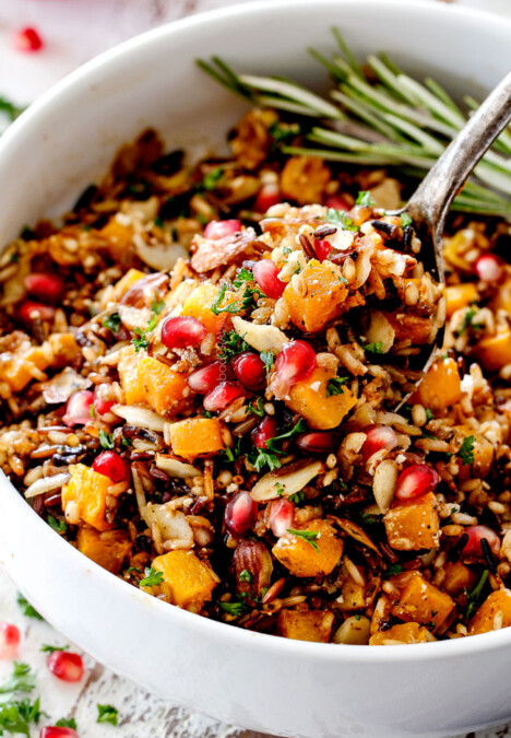 seasoned wild rice recipe with a spoon raising rice out of the bowl