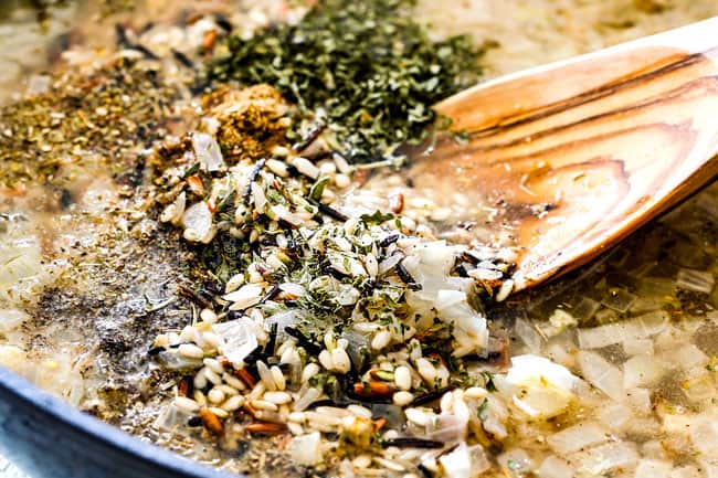 showing how to cook flavorful wild rice by adding wild rice, seasonings, herbs, onions and garlic to a saucepan