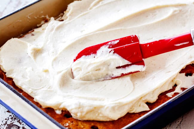 showing how to make poke cake by spreading frosting on top of poked cake