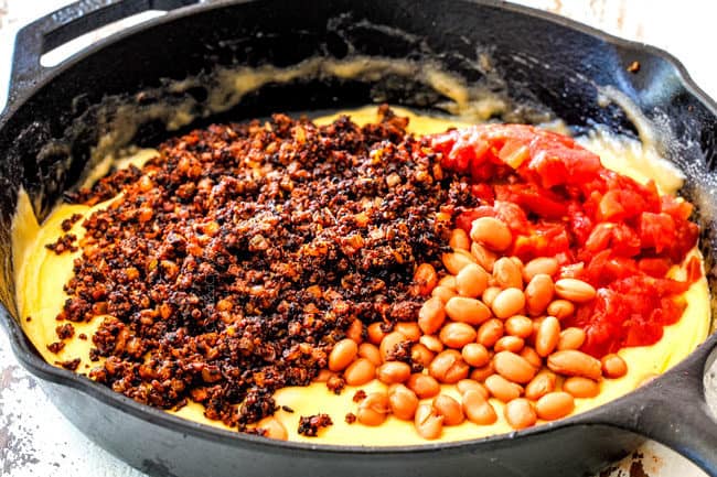 showing how to make Queso Fundido by adding chorizo, beans and tomatoes to melted cheese