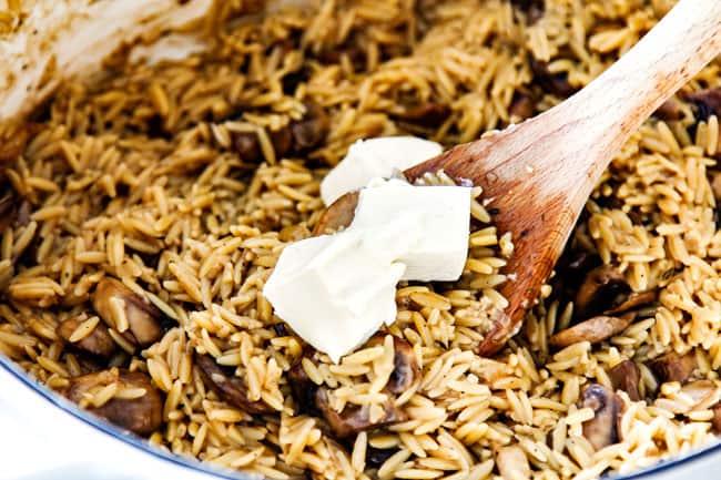 showing how to make creamy orzo pasta by stirring in cream cheese