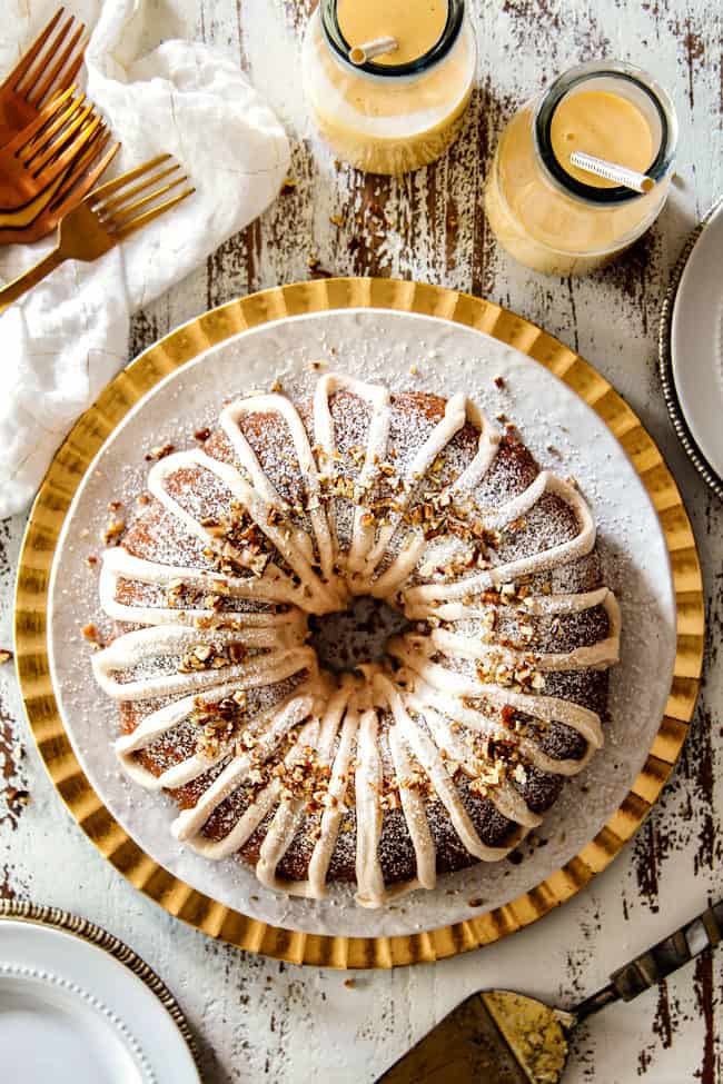 top view of tender Eggnog Cake on a white and gold platter with eggnog frosting