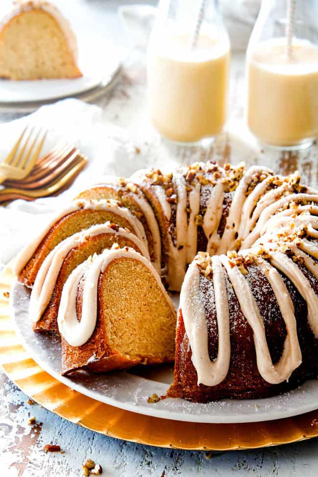 holiday eggnog cake on a white platter with two slices cut out