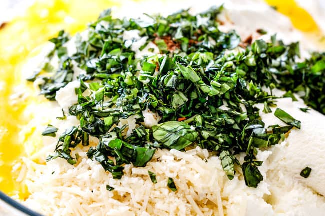 showing how to make lasagna by adding ricotta cheese, eggs, basil, nutmeg and Parmesan to a glass bowl