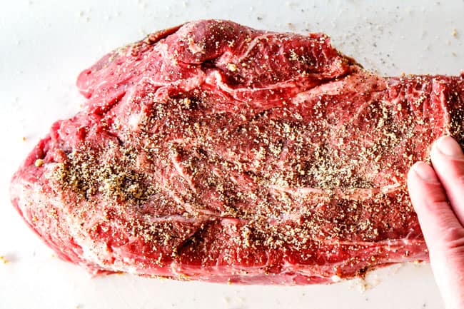 showing how to make Mississippi Pot Roast in crock pot by seasoning roast with garlic, onion powder and pepper