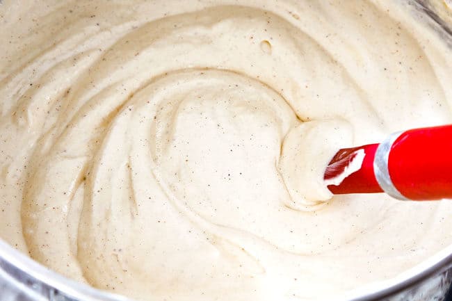 showing how to make easy pecan pie cheesecake by whipping cream cheese, brown sugar, sour cream, until smooth