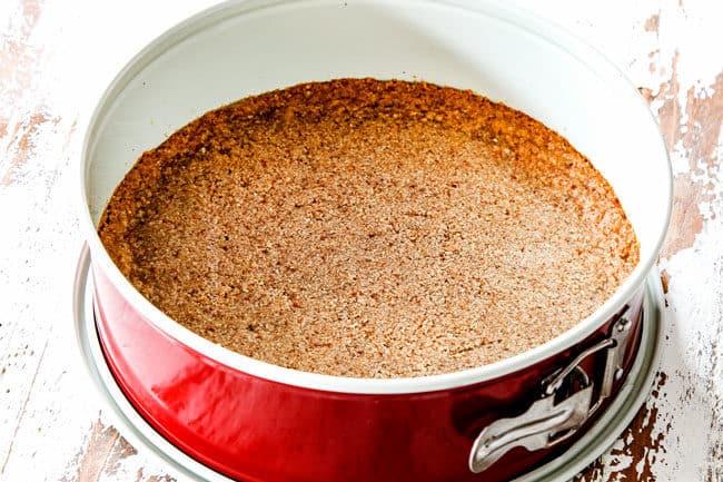 showing how to make easy pecan pie cheesecake by baking graham cracker crust in a springform pan