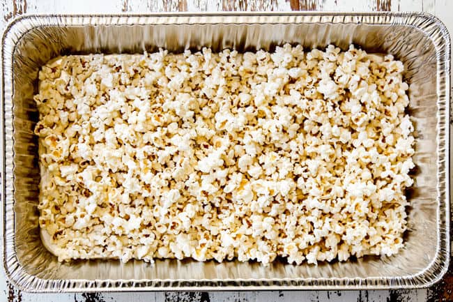 showing how to make caramel popcorn by adding popcorn to a large pan