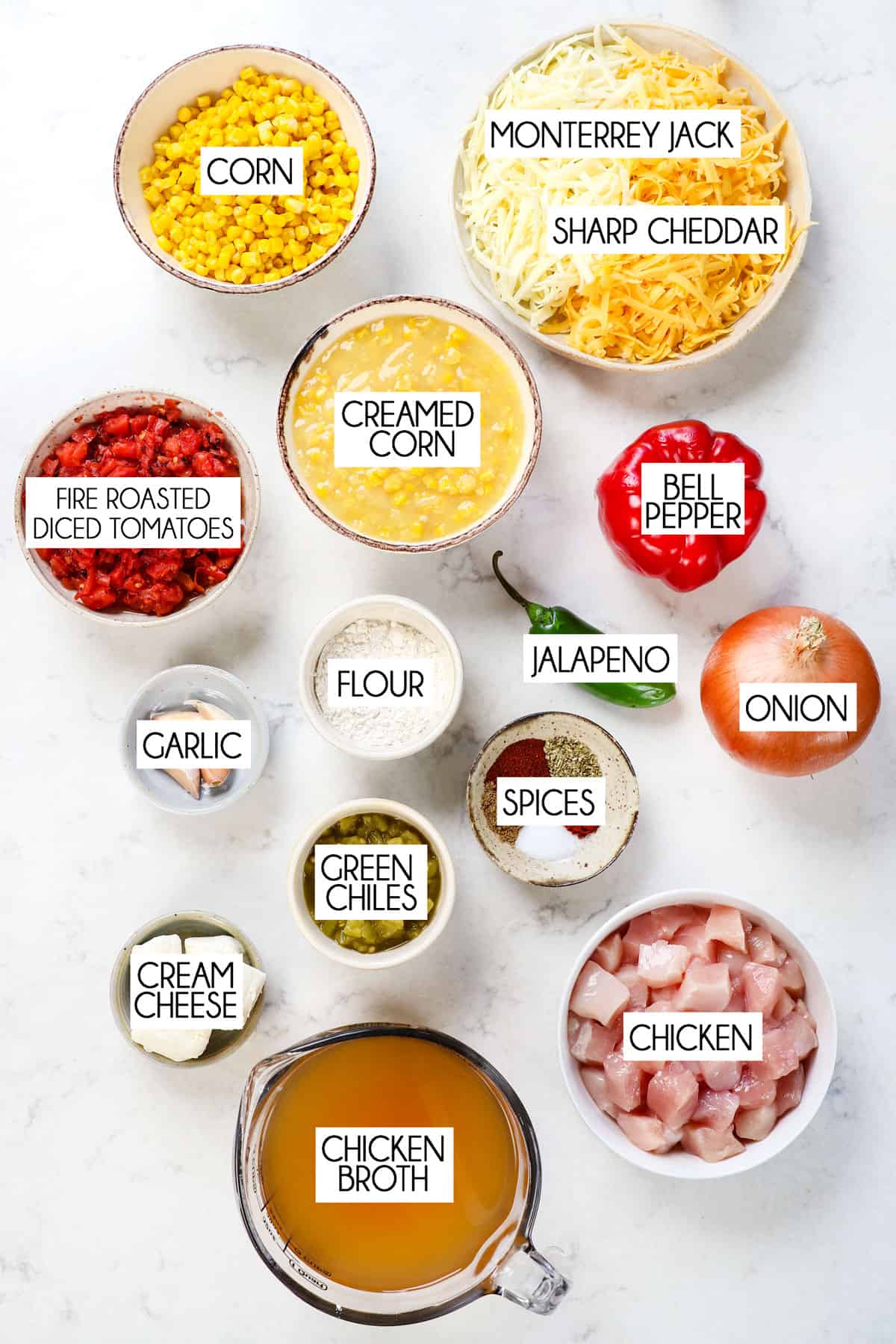 top view of chicken corn chowder recipe ingredients: diced chicken, corn, cream corn, chicken broth, flour, onions, garlic, tomatoes, jalapeno, green chiles, and spices.