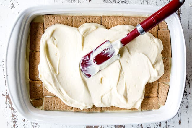 showing how to make Chocolate Eclair Cake by spreading vanilla pudding and whipped cream over graham crackers