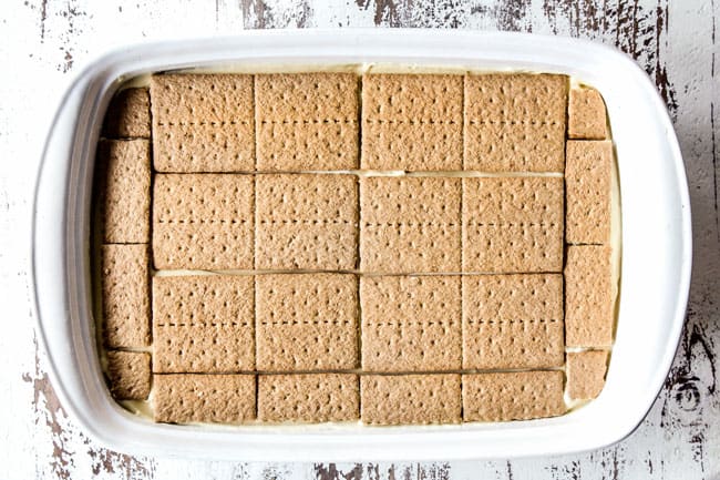 showing how to make Chocolate Eclair Cake by layering graham crackers over pudding