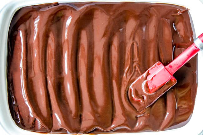 5 Minute Fool Proof Chocolate Ganache (sauce) is silky, creamy, sweet and 1,000 TIMES BETTER than any store bought chocolate sauce. Perfect for brownies, ice cream, cakes, popcorn, strawberries, etc showing how to make chocolate ganache glaze by spreading it over a cake