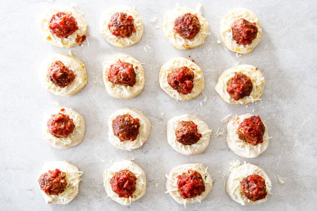 showing how to make pull apart bread by laying out biscuits and topping with cheese and meatballs