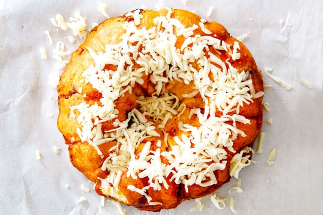 showing how to make pull apart bread by adding cheese to top of baked biscuits