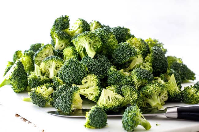 chopped broccoli florets on a white cutting board easy chicken divan recipe