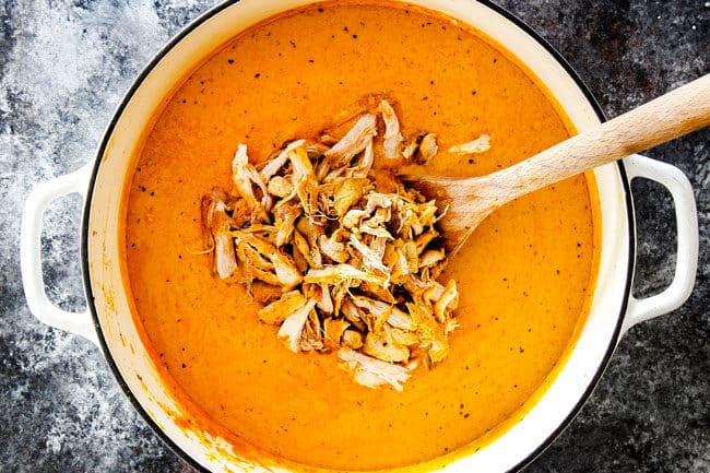 showing how to make homemade by adding shredded chicken to creamy coconut broth