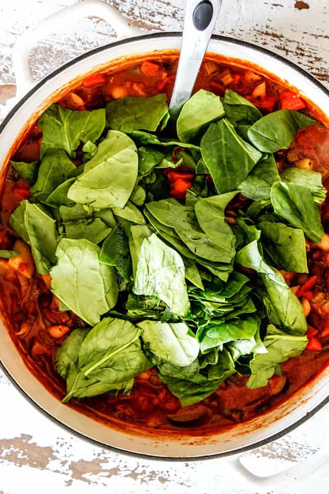 showing how to make easy Minestrone soup by adding spinach to soup