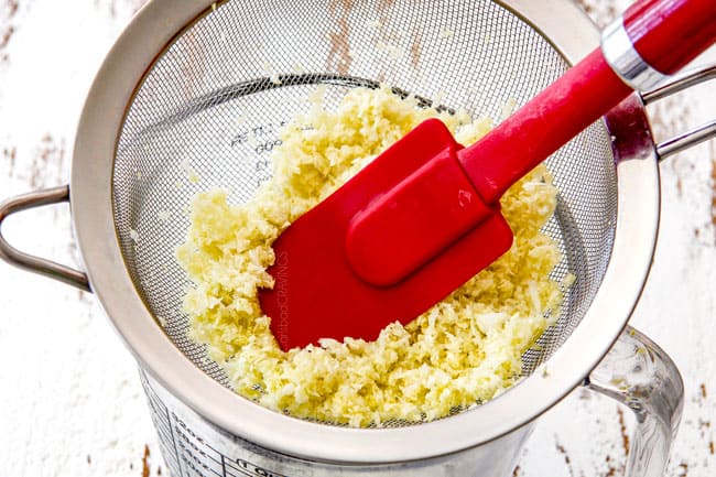 showing how to make the best potstickers by adding cabbage to a fine mesh sieve and pushing down with a spatula to release extra liquid