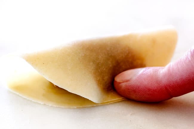 showing how to make potstickers by folding wrapper over in half and sealing
