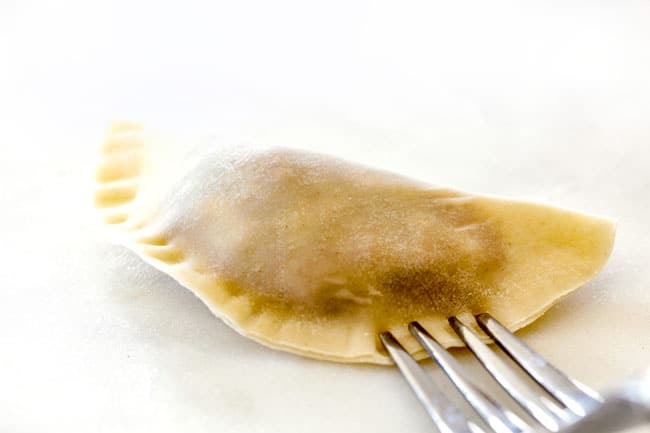 showing how to make potstickers by sealing the edges with the tongs of a fork